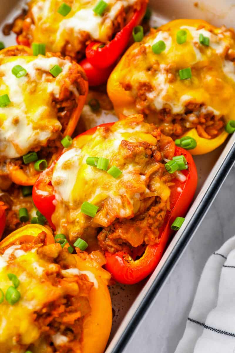 close up of stuffed peppers in a white rectangular baking pan.