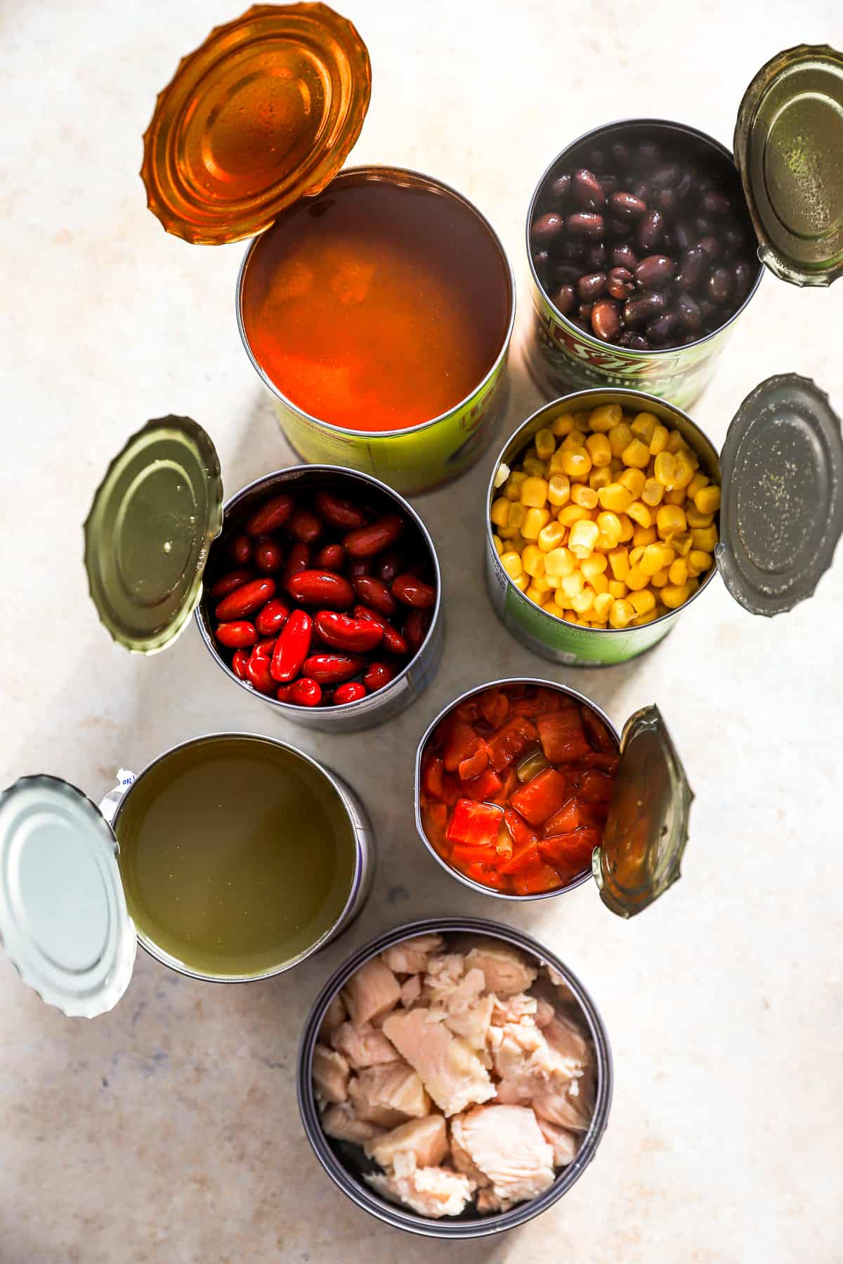 overhead view of ingredients for 7 can soup in open cans.