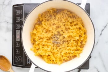 noodles and pepper added to chicken broth and bouillon in a dutch oven.