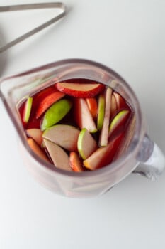 overhead view of red sangria in a large glass pitcher.