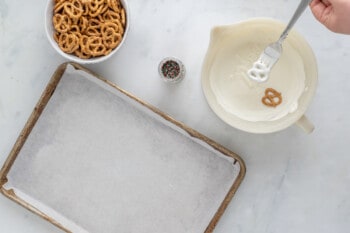 a person is mixing pretzels in a bowl with a spoon.