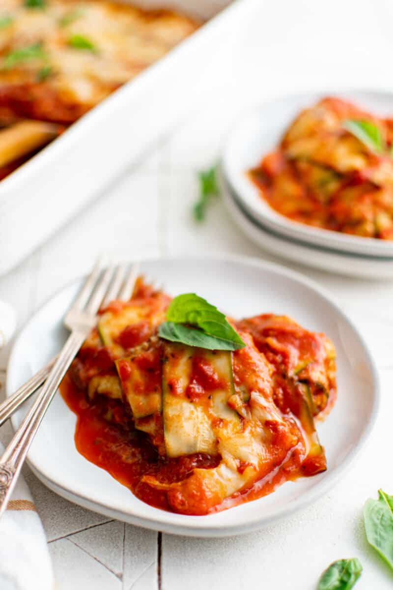 zucchini ravioli on a white plate with a fork.