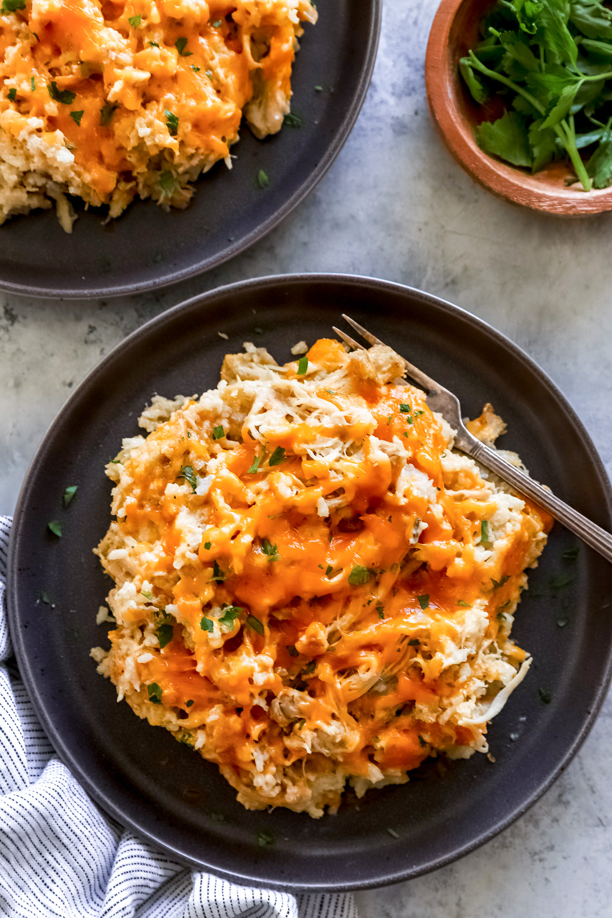 overhead view of crockpot chicken and rice on a black plate with a fork.