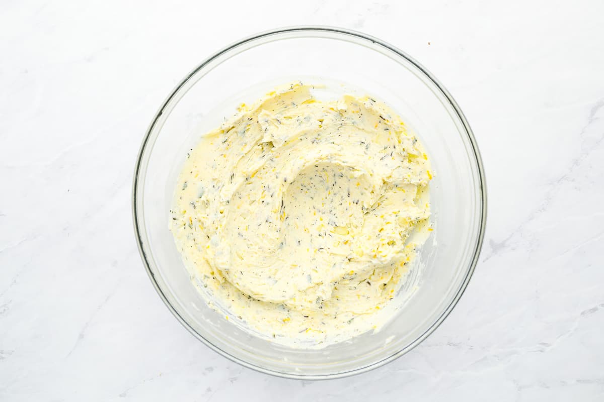 lemon butter in a glass bowl on a marble countertop.