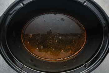 apple cider, brown sugar, and spices whisked together in a crockpot.