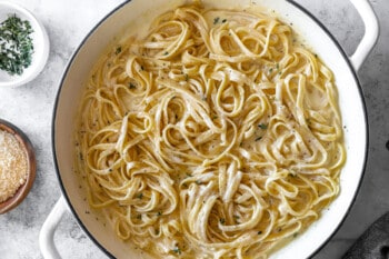 fettuccini alfredo in a white dutch oven.