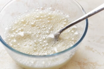 whipped egg whites in a glass bowl with a fork.