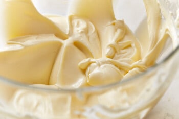 Italian cream cake frosting in a glass mixing bowl.