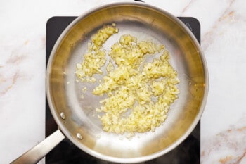 onion and garlic cooking in a frying pan.