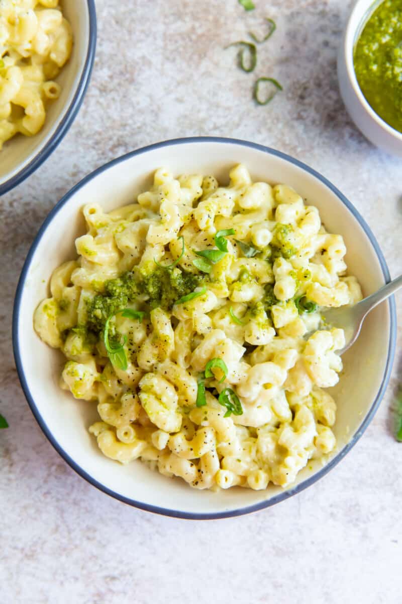 overhead view of pesto mac and cheese in a white bowl with a fork.