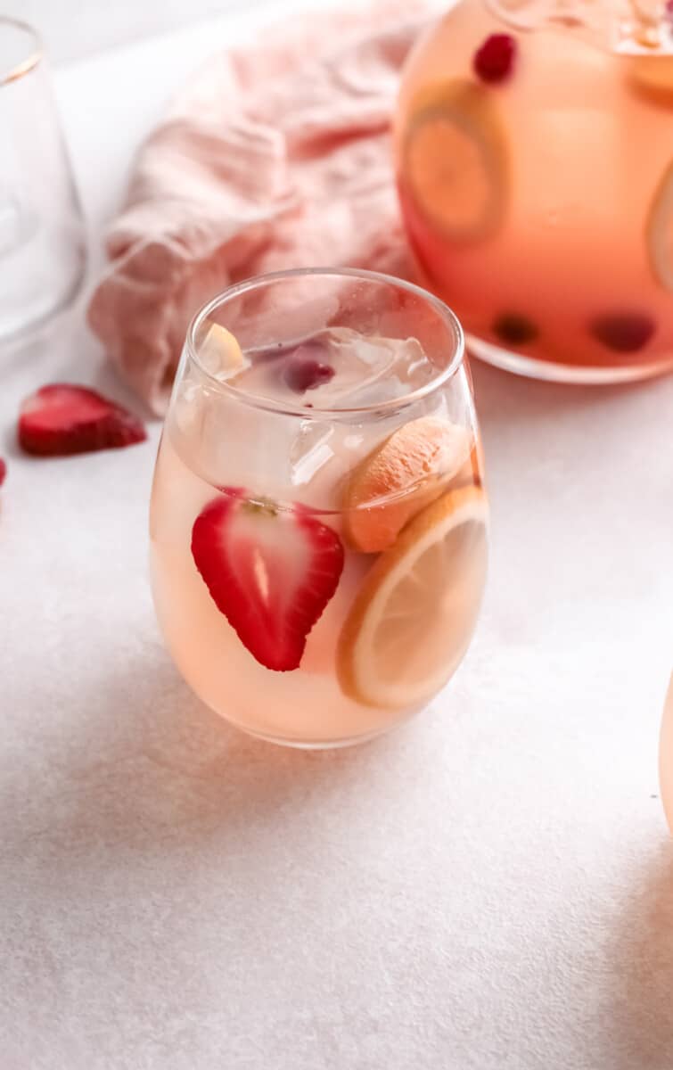 three-quarters view of a glass of rose sangria.