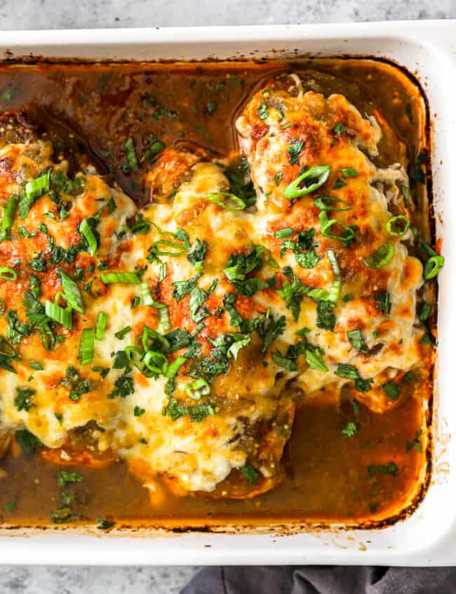 partial overhead view of salsa verde chicken breasts in a rectangular baking pan.