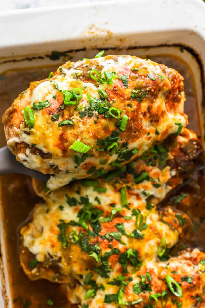 close up view of salsa verde chicken breasts in a rectangular baking pan.