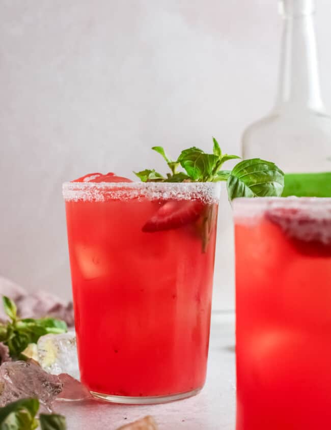 close up of 2 strawberry basil margaritas slightly offset.