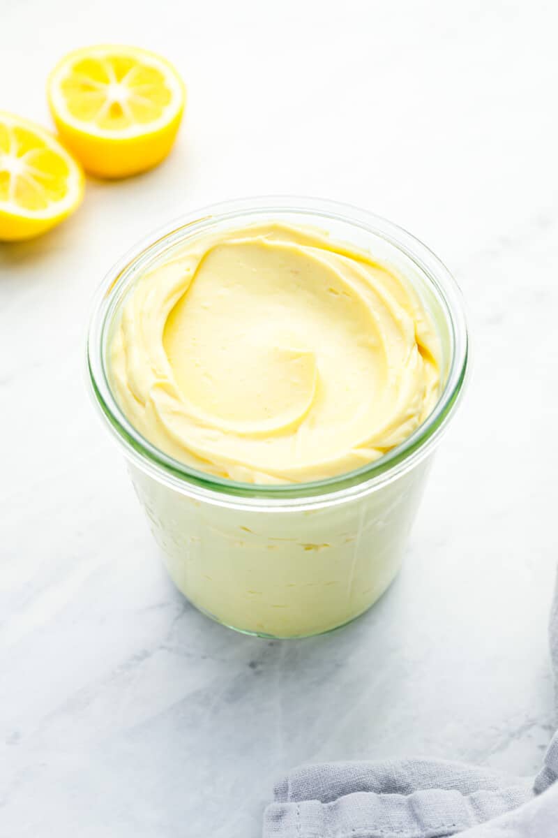 three-quarters view of homemade mayonnaise in a glass jar.