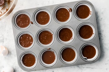 overhead view of chocolate cupcake batter in the wells of a cupcake tin.