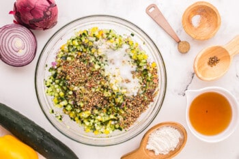 spices added to mixed veggies in a glass bowl.