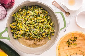 seasoned veggies added to simple syrup and flour mixture in a saucepan.