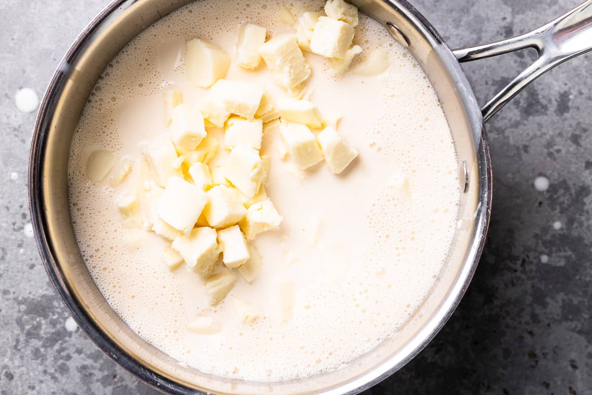 cubes of cheese and milk in a saucepan.