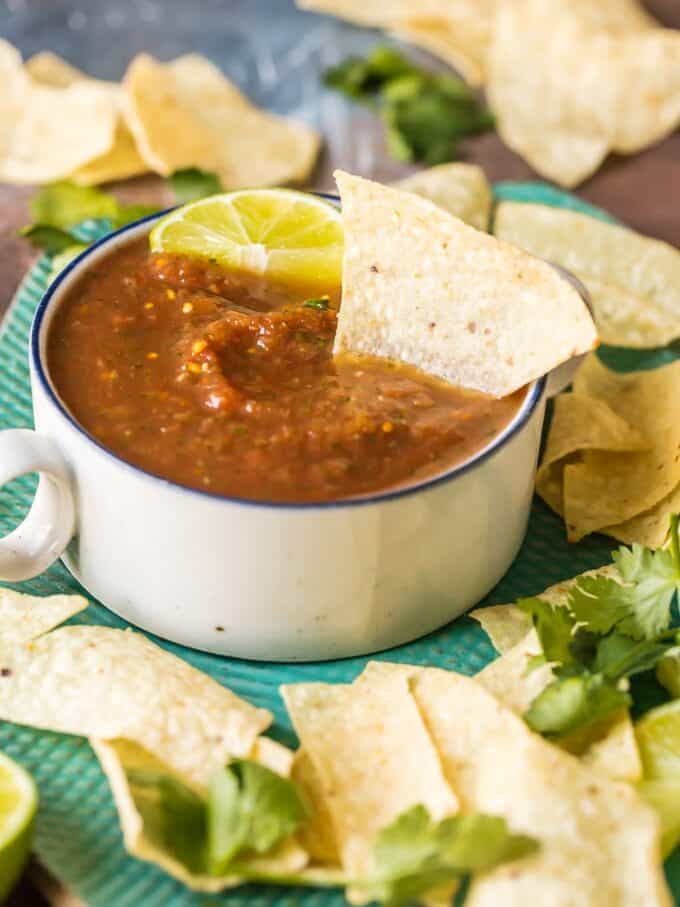 tortilla chip dipped into a bowl of blender salsa