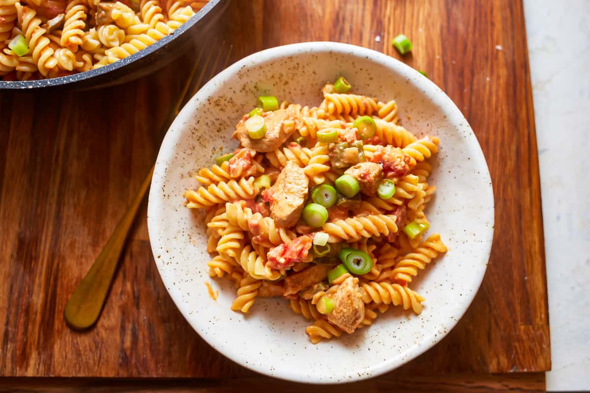 a serving of pasta in a bowl, set on a wood tabletop