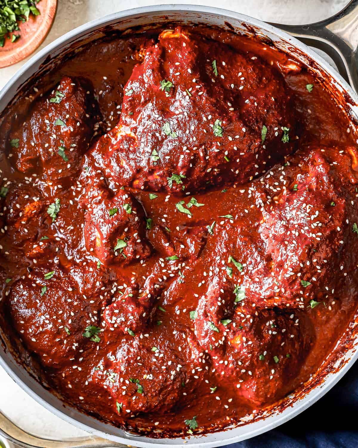 overhead view of chicken with mole sauce in a pot.