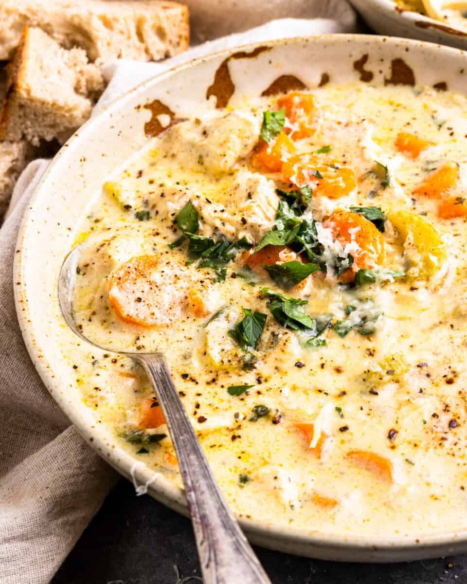 three-quarters view into a bowl of creamy chicken soup with vegetables.