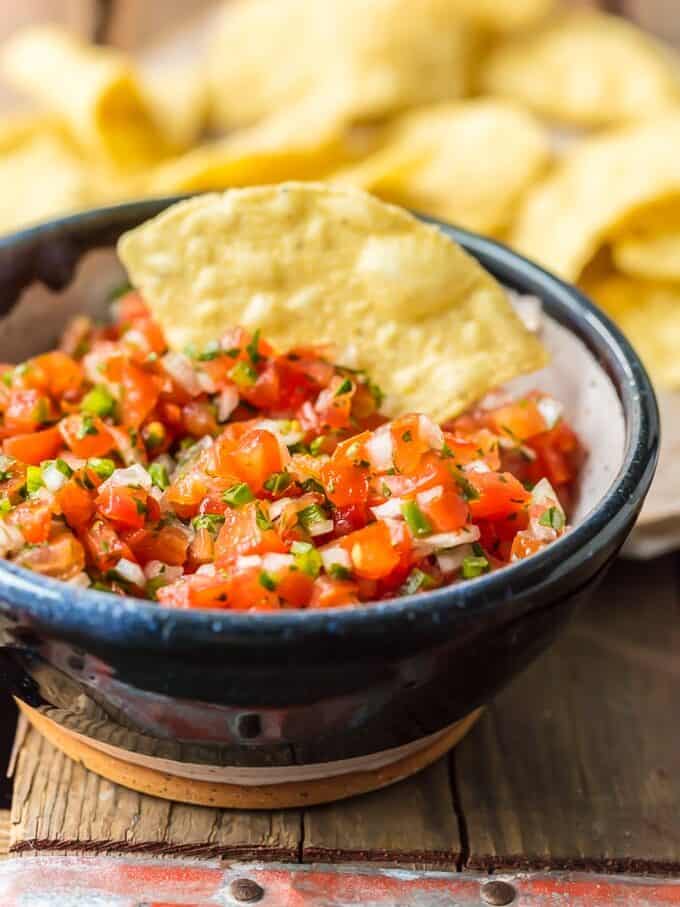 fresh pico de gallo in a bowl with a tortilla chip