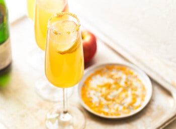 a tray with two glasses of champagne and a bottle of wine.