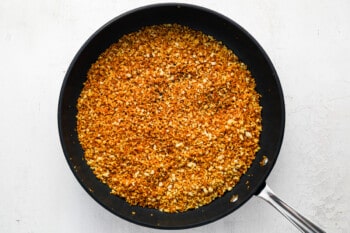 a frying pan filled with a mixture of spices.