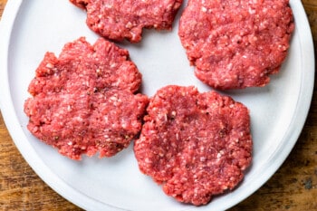 four burger patties on a plate