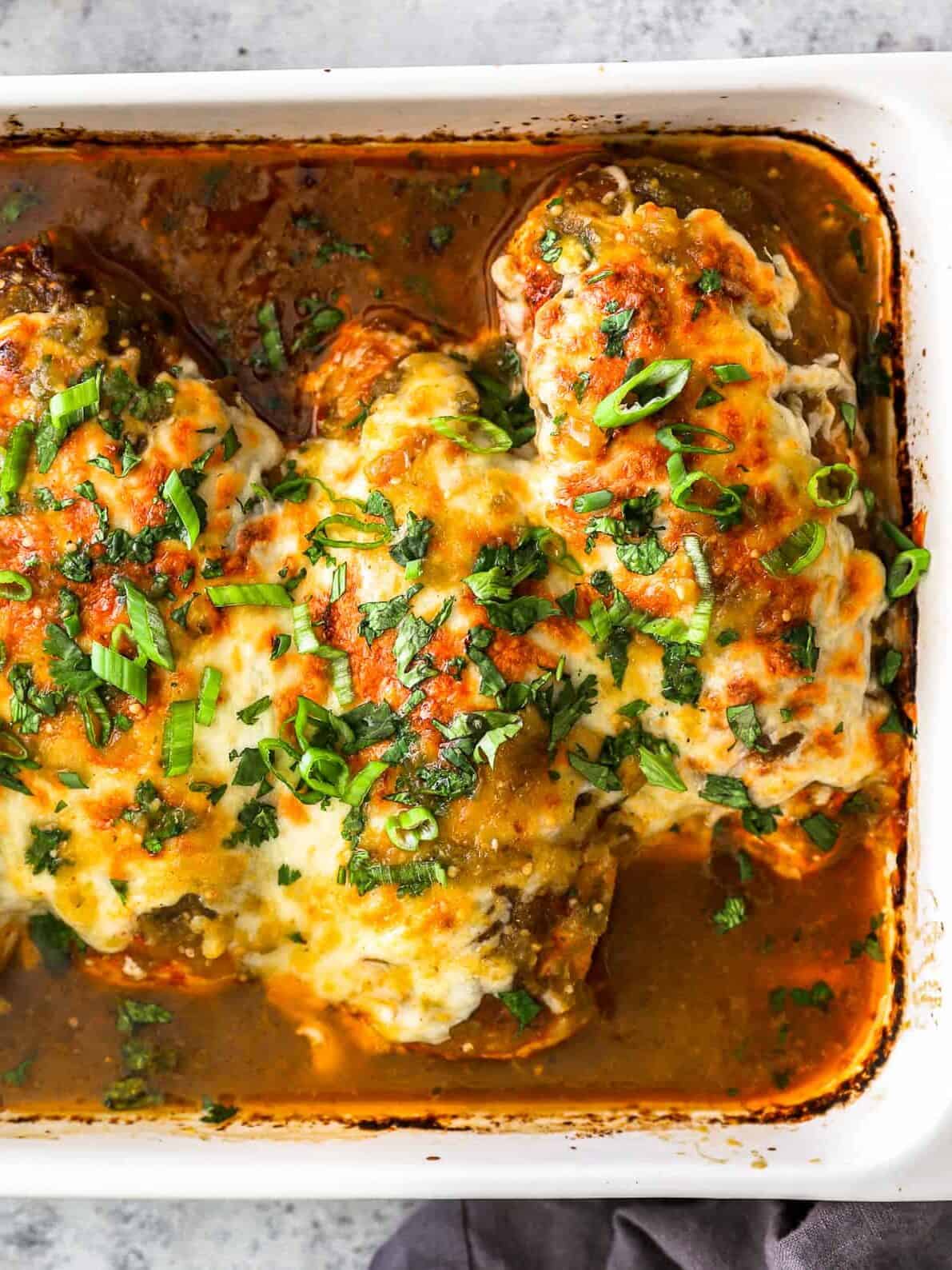 partial overhead view of salsa verde chicken breasts in a rectangular baking pan.