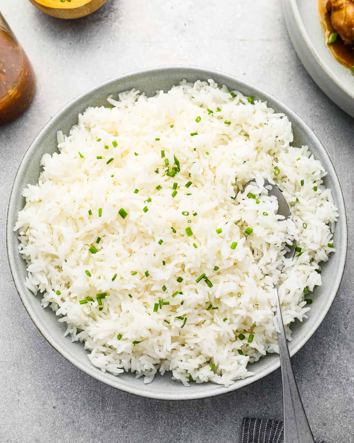 overhead view of stovetop basmati rice in a white bowl with a spoon.