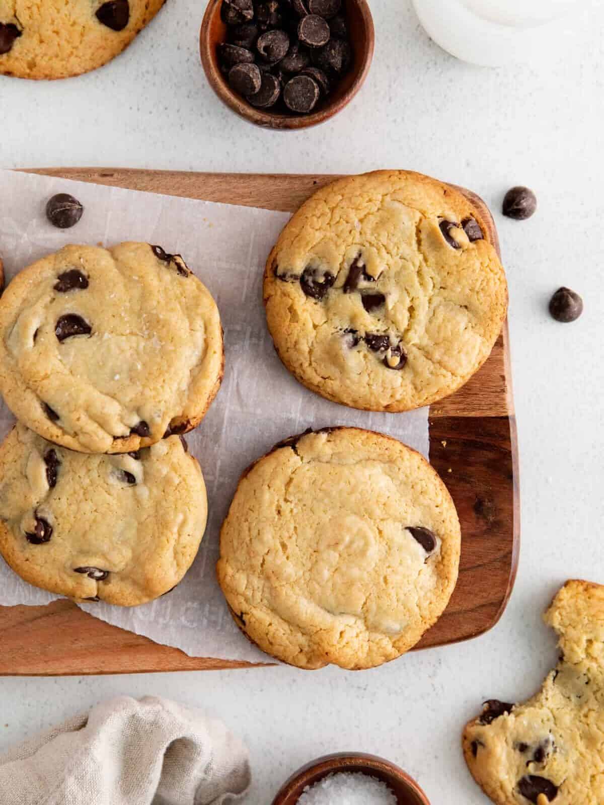 overhead view of 4 cake mix chocolate chip cookies on a cutting board.