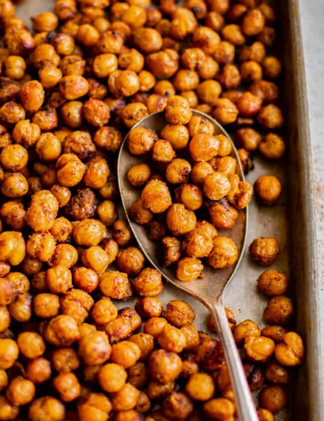 roasted chickpeas on a baking sheet with a spoon.