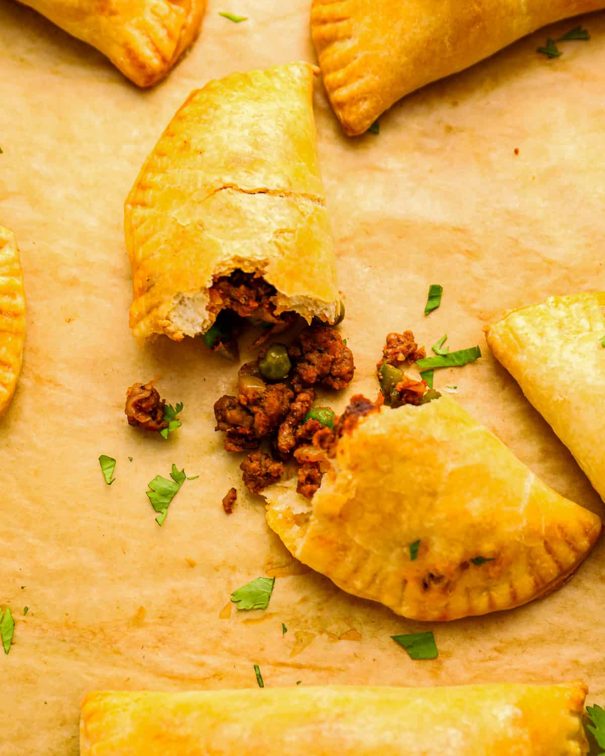 meat empanadas on a baking sheet.