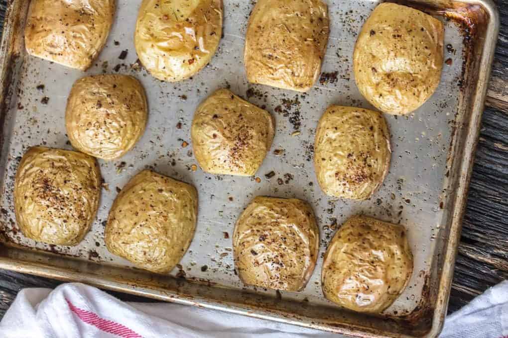 potatoes cut in half on a baking sheet