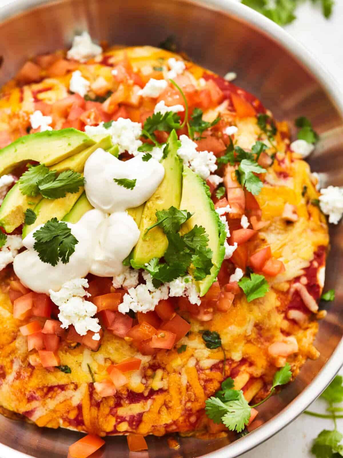 partial overhead view of a chicken enchilada skillet in a skillet.