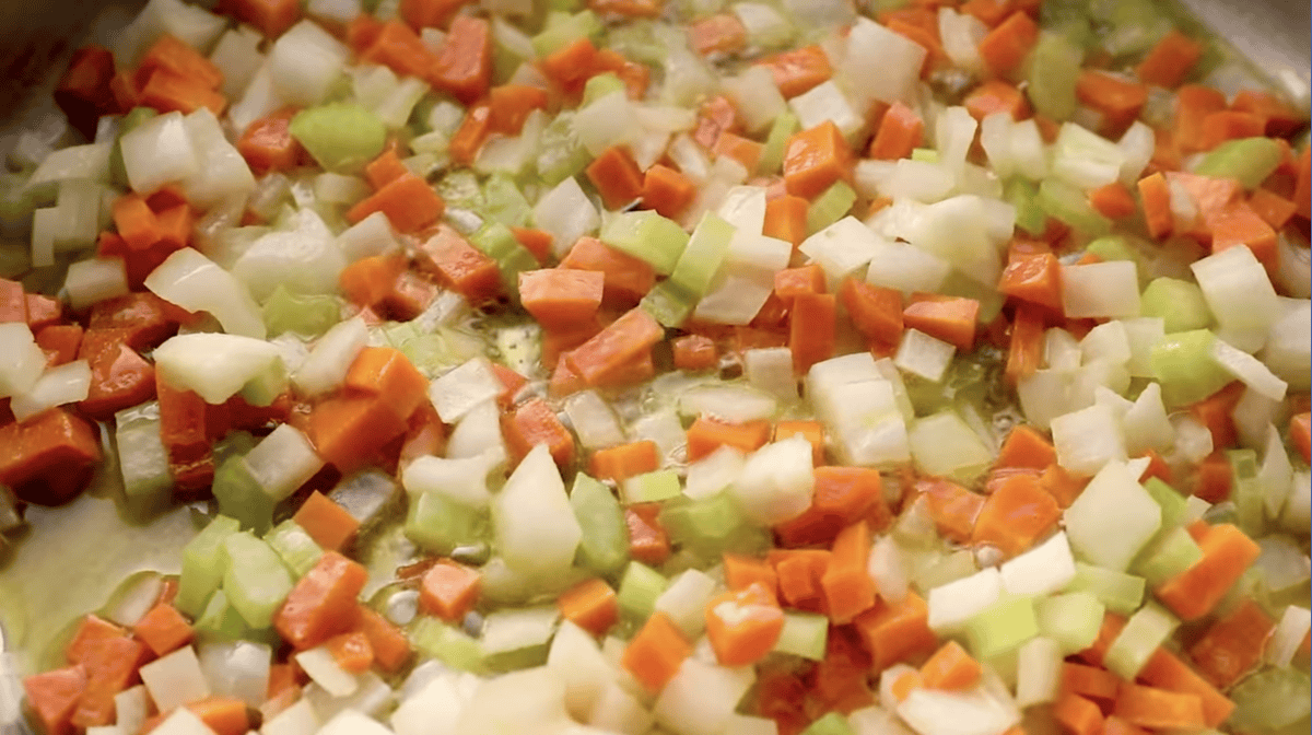 sautéed diced onions, carrots, and celery in a pan.