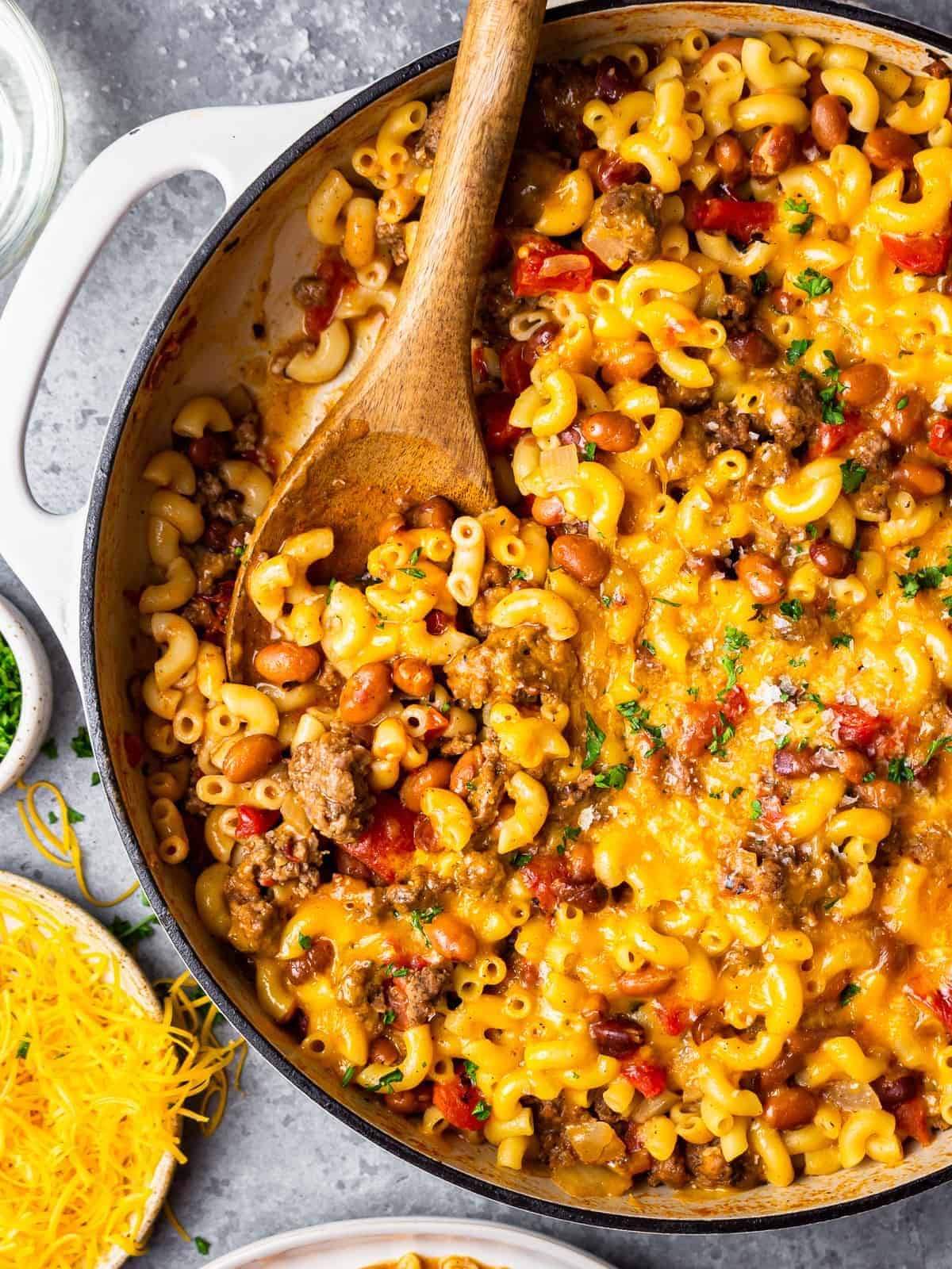 a pot of chili mac next to a plate