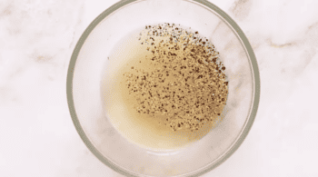 vinegar dressing with pepper in a glass bowl.