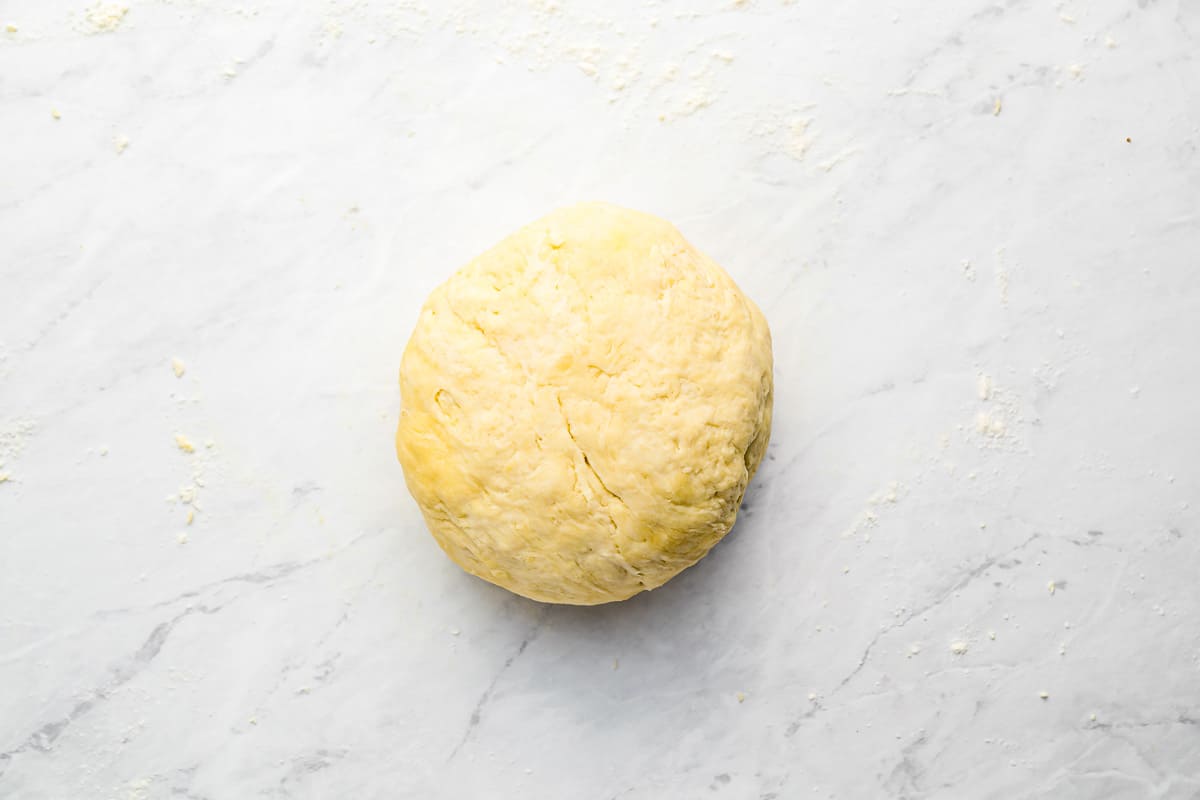 a ball of dough on a marble surface.