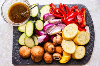 overhead view of ingredients for grilled vegetables on a cutting board.