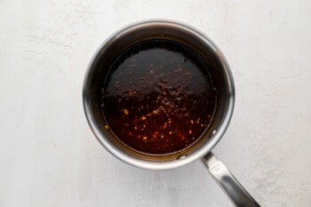 a pan with sauce in it on a white background.