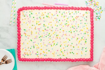 frosted vanilla sheet cake on a marble countertop.