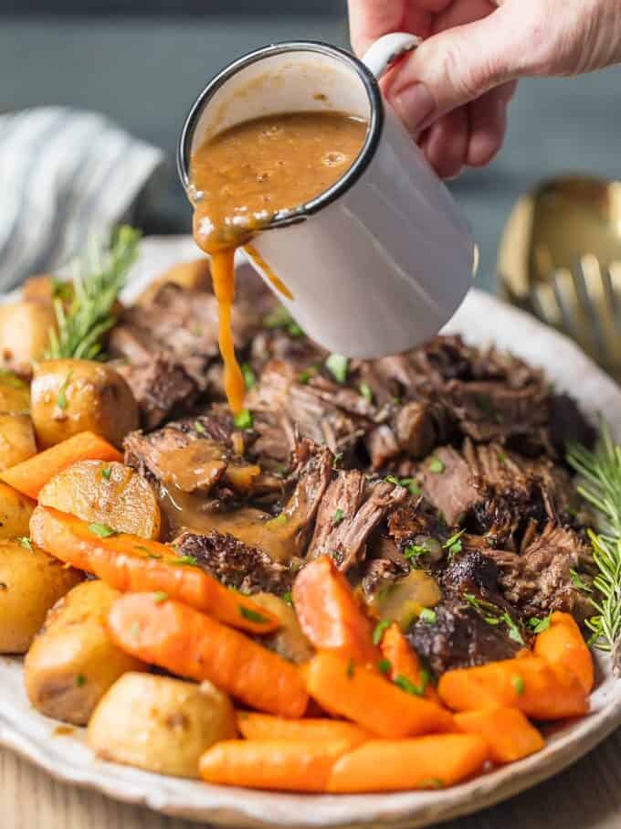 pouring gray over a platter of pot roast