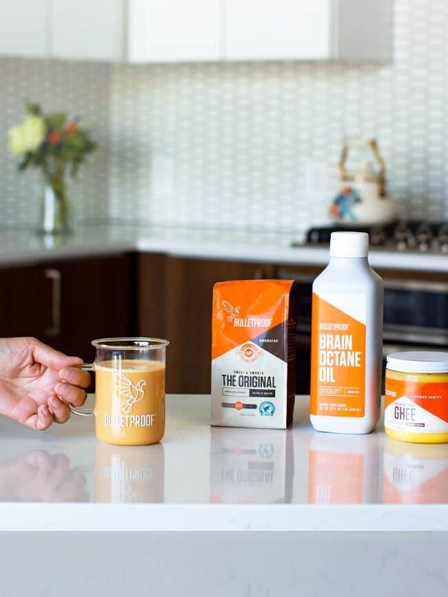 coffee cup, ground cofee, octane oil, and ghee on counter top