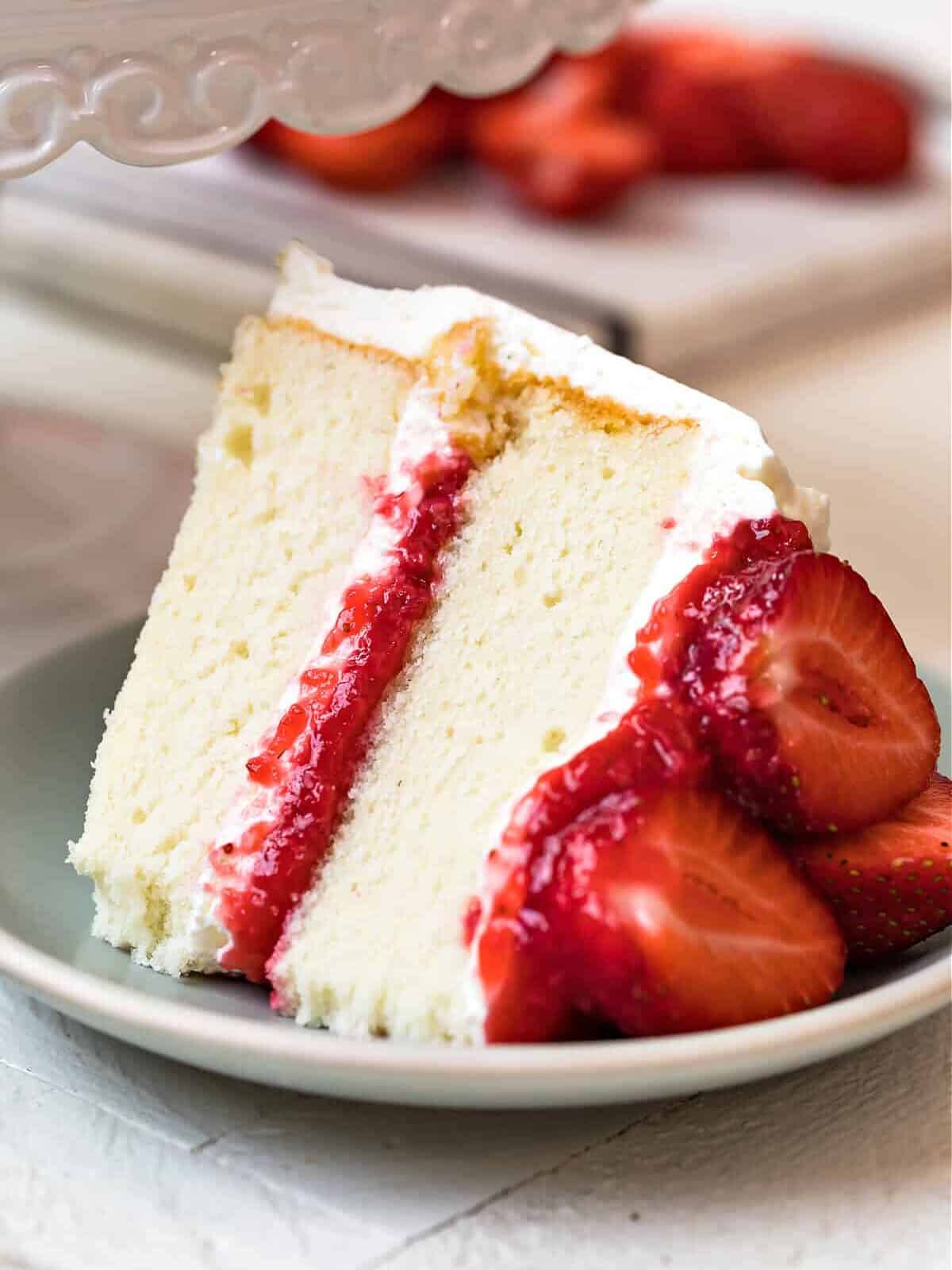 slice of white cake with strawberry filling and whipped cream frosting