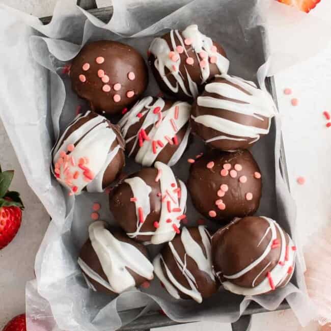 overhead view of strawberry truffles in a small parchment lined basket.