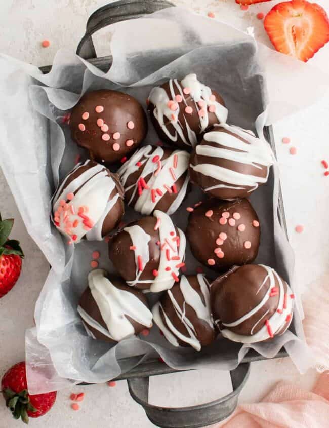 overhead view of strawberry truffles in a small parchment lined basket.